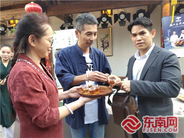 武夷山市回春巖茶廠相關負責人（中）邀請外國駐華使節(jié)品茶